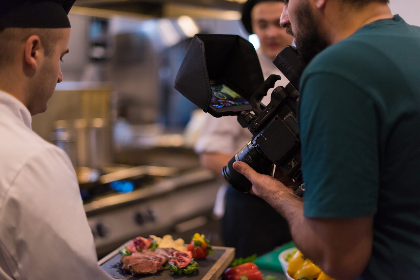 videographer recording while professional team cooks chefs preparing meal busy hotel restaurant kitchen scaled